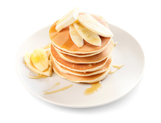 Tasty pancakes with honey, butter and banana on white background