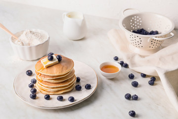 Tasty pancakes with honey, butter and berries on table