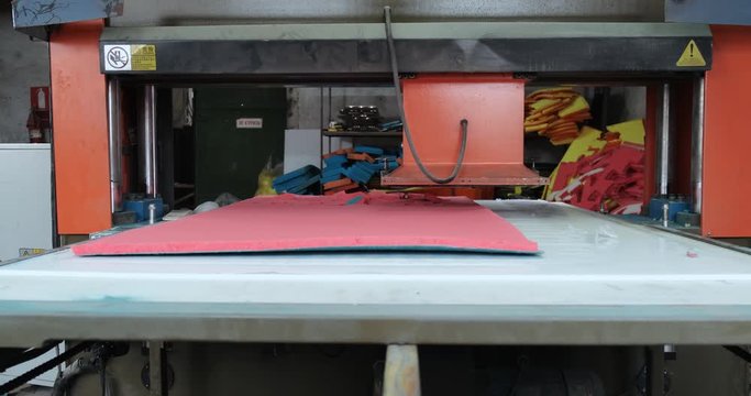 Heavy machine tool cuts out hexagonal workpieces from sheets of synthetic material, manufacturing paralon sponges for households, factory floor, automatic process, press, pressing, hexagonal shape