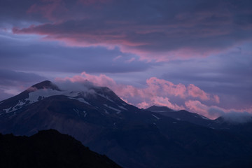 Mountain peak with snow and clouds during dramatic and colorful sunset on the laugavegur Hiking trail close to Thorsmork