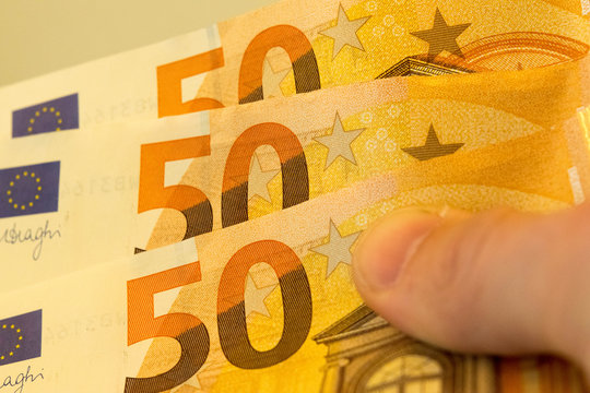 Three 50 euro bills in a hand. 150 Euro