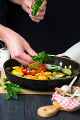 fried potatoes with vegetables, corn and spices in a pan