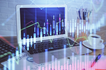 Stock market graph on background with desk and personal computer. Multi exposure. Concept of financial analysis.