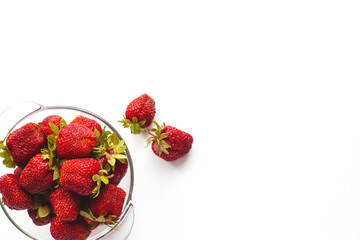 Juicy ripe strawberries in a bowl, isolated on a white background with space for text. The view from the top