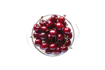 Juicy sweet cherries in a glass bowl, isolated on a white background