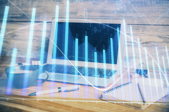 Double exposure of chart and financial info and work space with computer background. Concept of international online trading.