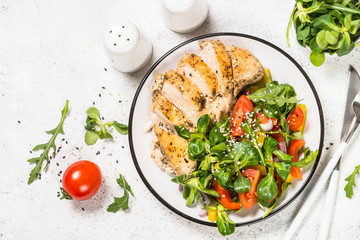 Baked chicken with fresh salad top view.
