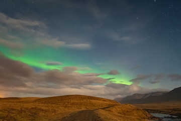 Obraz premium Aurora Borealis in Iceland northern lights bright stripe in sky during full moon night