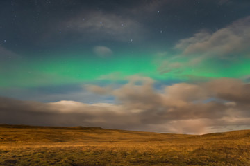 Naklejka na ściany i meble Aurora Borealis in Iceland northern lights shining green in night sky beyond the asterisk Big Dipper