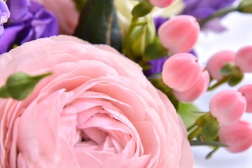 Bouquet of spring flowers with beautiful pink ranunculus flower, pink berries and violet tender flowers. Soft focus. Spring time 