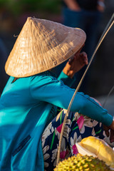 Unidentified Vietnamese merchants wearing traditional Vietnamese style conical hat "non la".