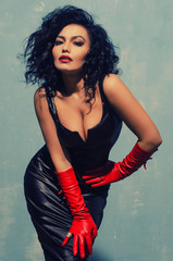 Beautiful fetish model wearing black spandex dress and long red leather gloves