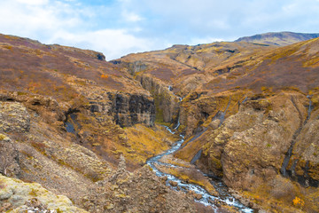 Glymur waterfall in Iceland gorge behind fall cutting through colorful autumn landscape