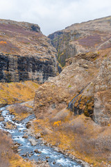 Glymur waterfall in Iceland gorge behind fall cutting through autumn landscape