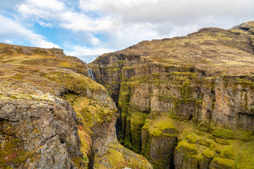 Glymur waterfall in Iceland gorge behind fall overgrown green canyon