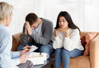 Unhappy Couple Sitting In Family Psychologist's Office, Selective Focus