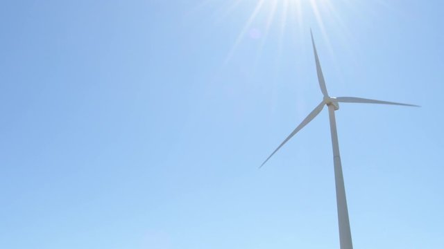 Wind turbine of renewable energy moving a sunny day with blue sky