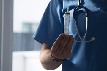 doctor with stethoscope and syringe, medicine and infections concept