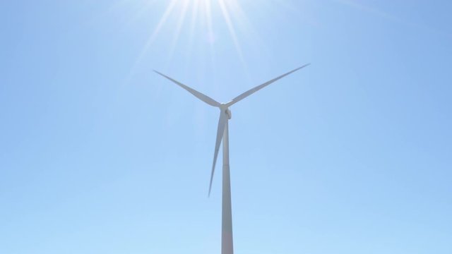 Wind turbine moving a sunny day with blue sky
