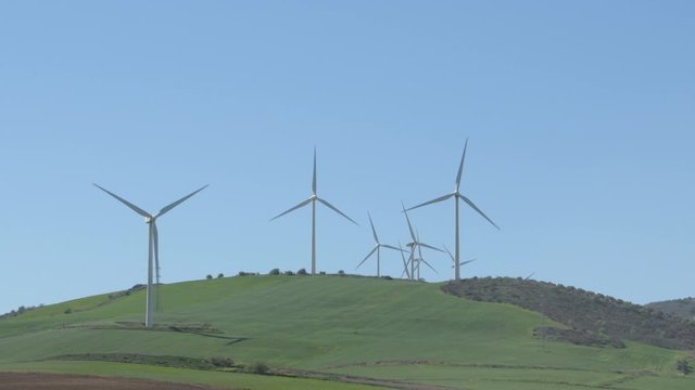 Landscape of wind turbines of renewable energy in the field moving with blue sky