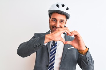 Young handsome business man wearing suit and tie and bike helmet over isolated background smiling in love showing heart symbol and shape with hands. Romantic concept.