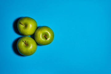 Green apple on blue background. Flat lay, top view, copy space . Food dietary concept.