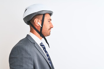 Young handsome business man bike helmet and wireless earphones over isolated background looking to side, relax profile pose with natural face with confident smile.