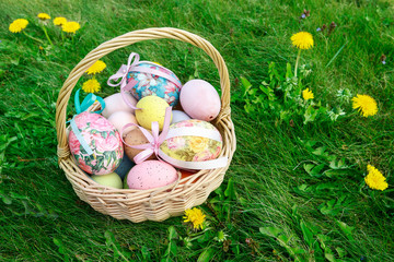 Wicker basket with Easter eggs in the garden.