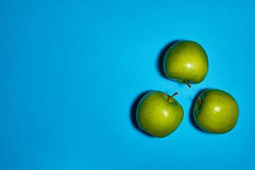 Green apple on blue background. Flat lay, top view, copy space . Food dietary concept.