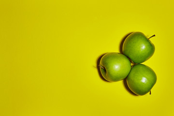 Green apple on yellow background. Flat lay, top view, copy space . Food dietary concept.