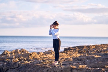 Young beautiful sportwoman practicing yoga. Coach teaching mountain pose at the beach