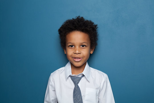 African American black child boy in white shirt and tie on blue background