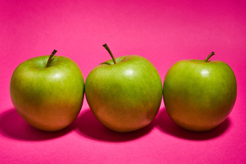 Green apple on pink background. Flat lay, top view, copy space . Food dietary concept.