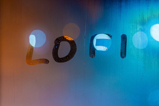 the word lofi written by finger on night wet window glass, blue and orange colors