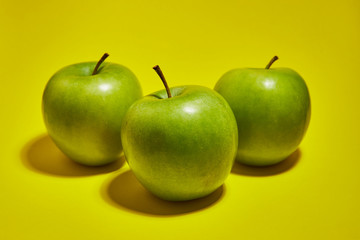 Green apple on yellow background. Flat lay, top view, copy space . Food dietary concept.