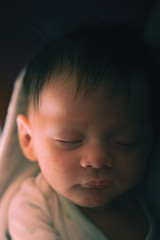 Cute little baby sleeping on knitted plaid in cradle, closeup