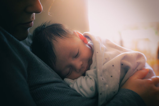 Mother and her Newborn Baby. Happy Mother and Baby kissing and hugging. Maternity concept. Parenthood. Motherhood.