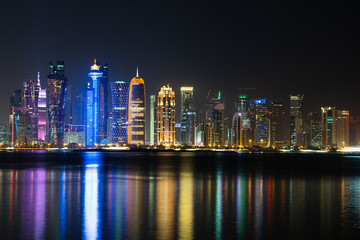 Obraz na płótnie Canvas Vibrant Skyline of Doha at Night as seen from the opposite side of the capital city bay at night