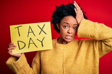 Young African American afro woman with curly hair holding paper with tax day message stressed with...