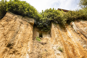 Fototapeta na wymiar bottom-up view of tuff rock cliff in Sutri, province of Viterbo, Lazio, Italy