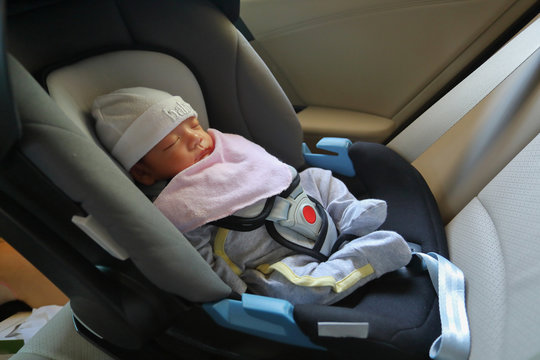 cute newborn baby sleeping in car seat safety belt lock protection drive road trip