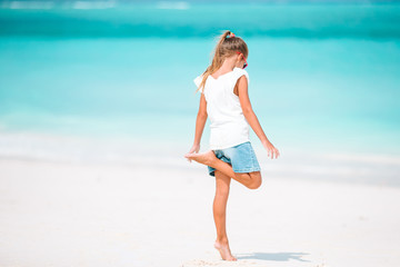 Fototapeta na wymiar Adorable little girl have fun at tropical beach during vacation