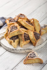 Traditional Jewish Hamantaschen cookies with  dried apricots, dates. Purim celebration concept. Сarnival holiday background. Selective focus. Copy space.