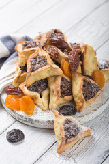 Traditional Jewish Hamantaschen cookies with  dried apricots, dates. Purim celebration concept. Сarnival holiday background. Selective focus. Copy space.