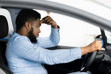 Depressed Man Sitting In Driver's Seat Of Too Expensive Car