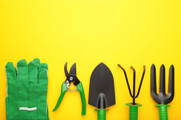 Gardening tools on yellow background, top view