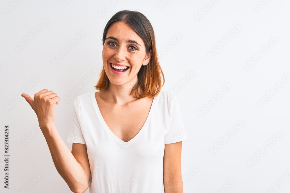 Wall mural beautiful redhead woman wearing casual white t-shirt over isolated background smiling with happy fac