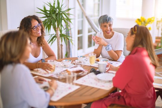 Young beautiful girl smiling happy and confident sitting dinking cup of coffee at terrace