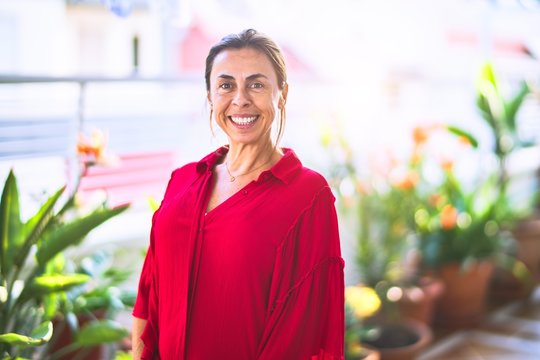 Middle age beautiful woman smiling happy and confident standing with a smile on face at terrace
