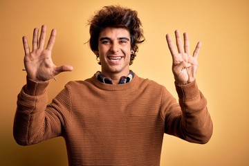 Young handsome man wearing casual shirt and sweater over isolated yellow background showing and...